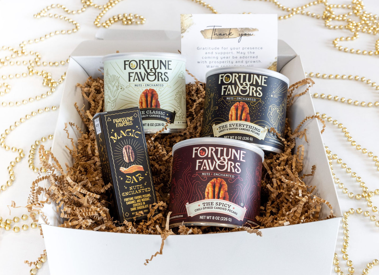A Fortune Favors gift box with three cans, a Magic Bar and a printed thank-you card